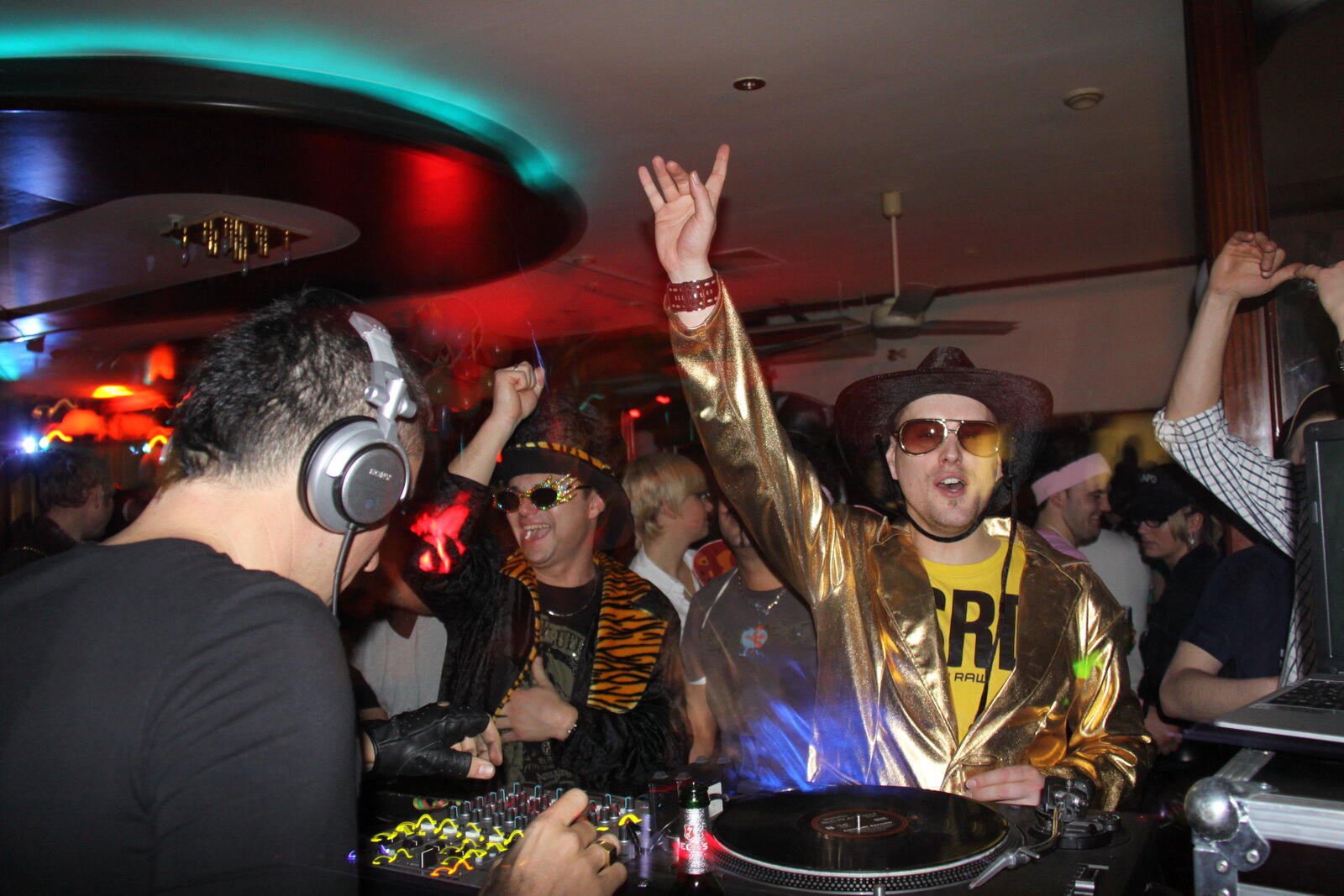 DJ Nice en b2b dans un club, soirée veste dorée mains levées